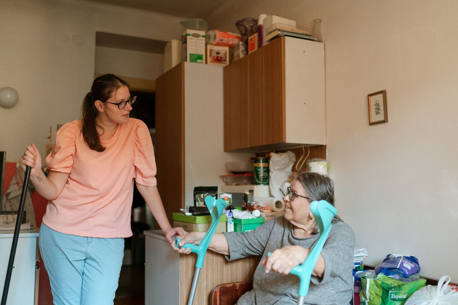 An older adult with crutches receiving one-to-one support at home