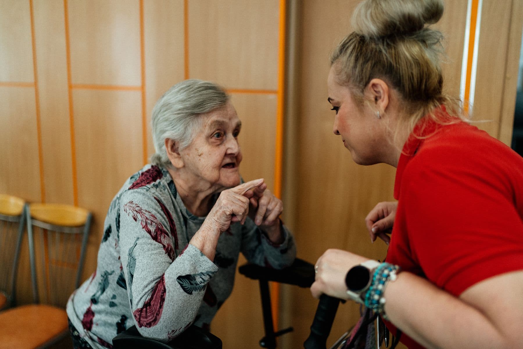A care professional listening closely to an older adult