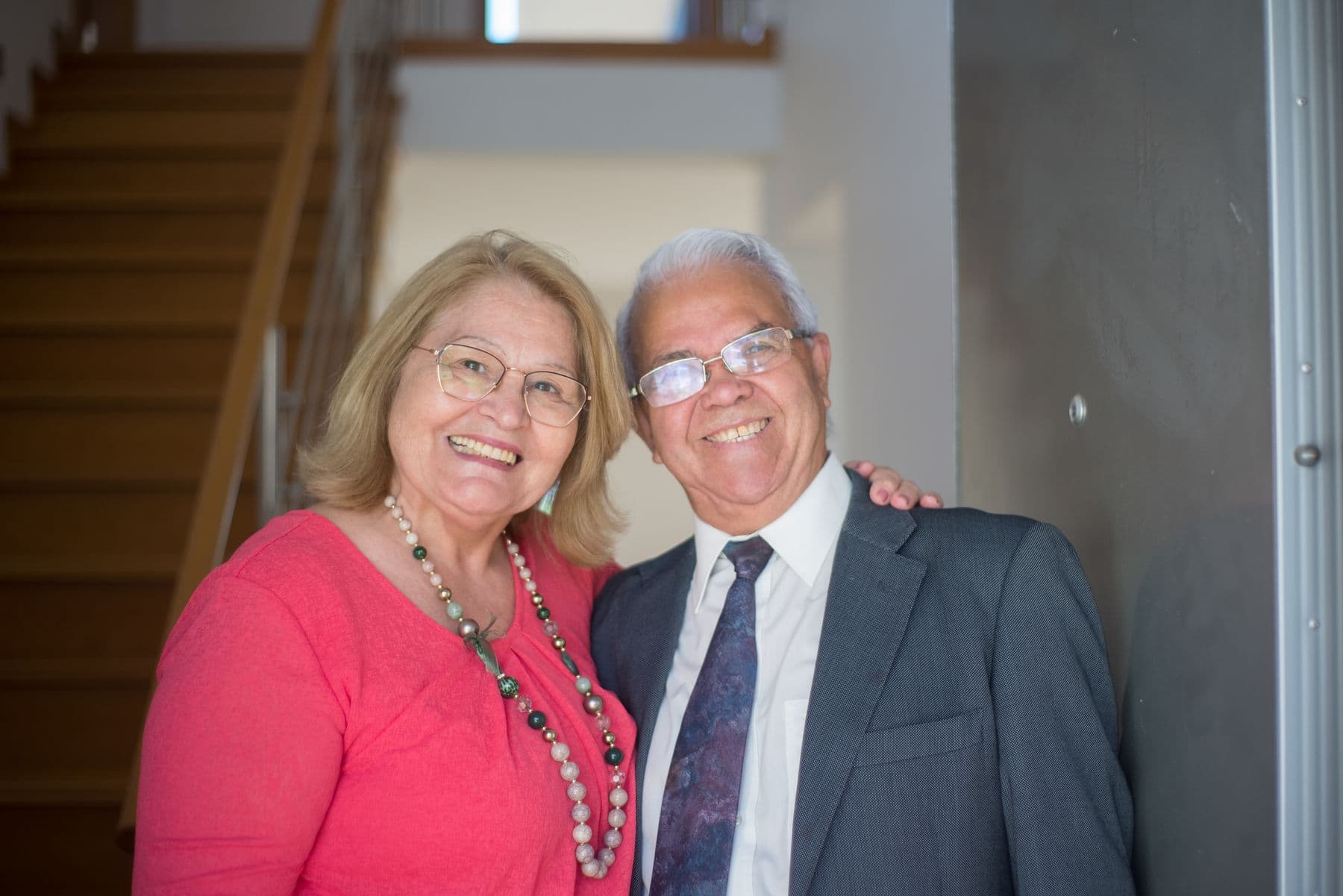 An older couple standing together at the entrance to their home